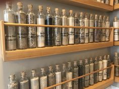 an assortment of spices on wooden shelves in a store