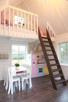 there is a loft bed with stairs to the second floor and a table in front of it