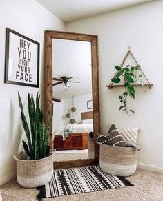 a large mirror sitting on top of a white wall next to a potted plant