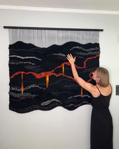 a woman is working on a piece of art that looks like waves and the sky