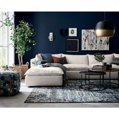 a living room with blue walls and white furniture in the corner, including a large sectional couch