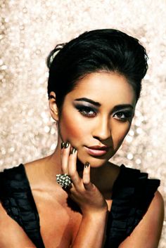 a woman with gold and black nail polish on her nails, posing for the camera