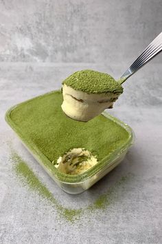 a spoon scooping green tea ice cream out of a container