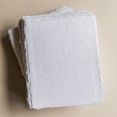 three pieces of white paper sitting on top of each other