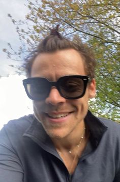 a man wearing sunglasses is smiling for the camera