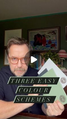 a man holding up three easy color schemes in front of his face and the words, three easy