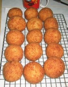 several muffins on a cooling rack next to a mug