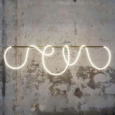 a neon sign that is hanging on the side of a wall with wires attached to it