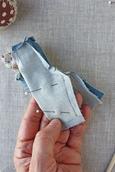 someone is stitching together fabric to make an origami bird