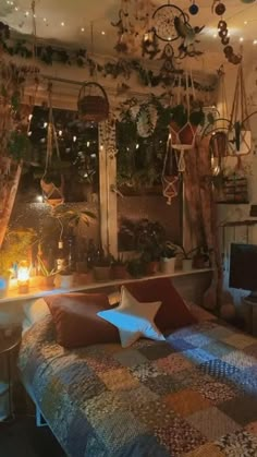 a bed sitting in a bedroom next to a window with lots of hanging plants on it