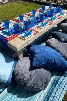 a picnic table set up with pillows and place settings