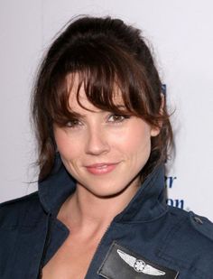 a woman with short hair wearing a blue jacket