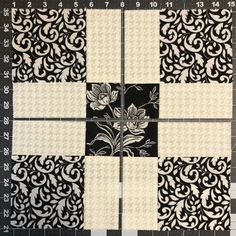 the block is made up of black and white fabric with flowers on it, along with numbers