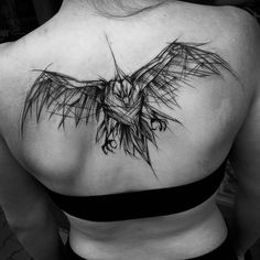 the back of a woman's shoulder with a bird tattoo on it