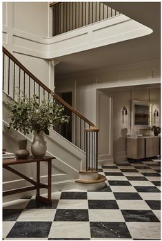 a black and white checkered floor with vases on the table next to it