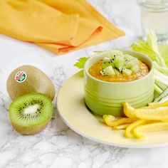 a kiwi fruit and vegetable dish on a plate next to some sliced kiwis