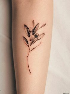 a tattoo on the leg of a woman's legs with flowers and leaves painted on it