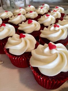 red velvet cupcakes with white frosting and hearts on the top are ready to be eaten