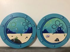 two blue plates with sea animals painted on them sitting on a shelf next to each other