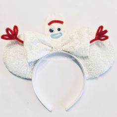 a white headband with a red and blue monkey on it's side, sitting next to a white background