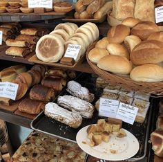 many different types of breads and pastries on display