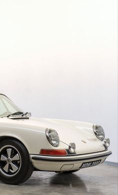 an old white car parked in a garage