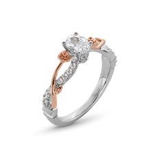 a white and rose gold engagement ring with an oval cut diamond in the center, set on