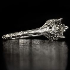 an antique silver hair clip with filigrees and flowers on the side, sitting on a table