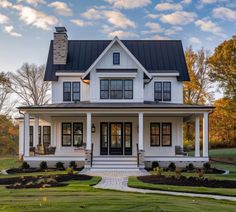 a white house with black roof and front porch