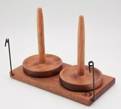 two wooden pegs on top of each other with black pins sticking out of them