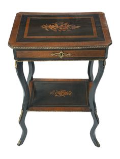 an antique wooden table with black and gold trimmings on the top, sitting against a white background