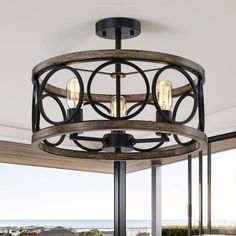 the light fixture is hanging from the ceiling in front of a large window with an ocean view