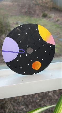 a paper plate with an image of the solar system on it sitting in front of a window