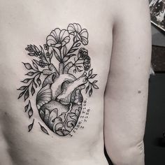 a black and white photo of a heart with flowers on it's side chest