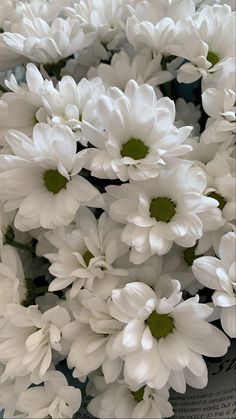 white flowers are in a vase on the table