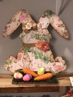 an easter bunny sitting on top of a wooden shelf