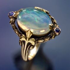 Gold Water Opal Sapphire, H: 1.8 cm (0.71 in),   British, c.1920 Sibyl Dunlop, Water Opal, Bijoux Art Nouveau, Art Nouveau Ring, Body Accessories, Magic Items, Gold Water, Blue Stones, Antique Ring