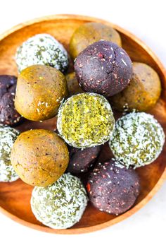 a wooden bowl filled with different types of chocolate truffles covered in sprinkles