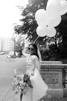 black and white photograph of a bride holding balloons