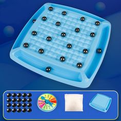 an ice tray with black balls on it and a game board next to it,