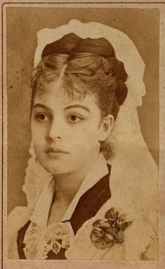 an old photo of a young woman wearing a wedding dress and veil with flowers in her hair