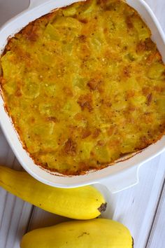 a casserole dish with two bananas next to it on a white table top