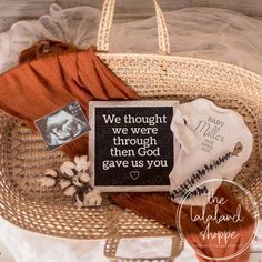 a basket filled with clothing and a sign that says we thought we were through then god gave us you