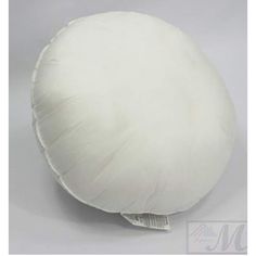 a white round pillow sitting on top of a table