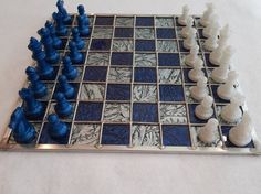 a blue and white chess board with pieces on it