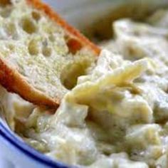 a close up of a bowl of food with some bread sticking out of it's side