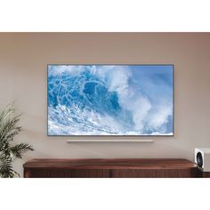 a flat screen tv sitting on top of a wooden cabinet in front of a wall