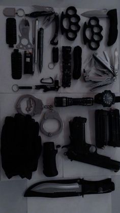 there are many different types of knives and tools on the table, all in black