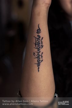 a woman's arm with the word tattoo written in cursive writing on it