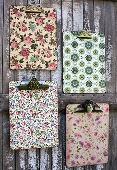 four flowered notebooks hanging on a wooden wall